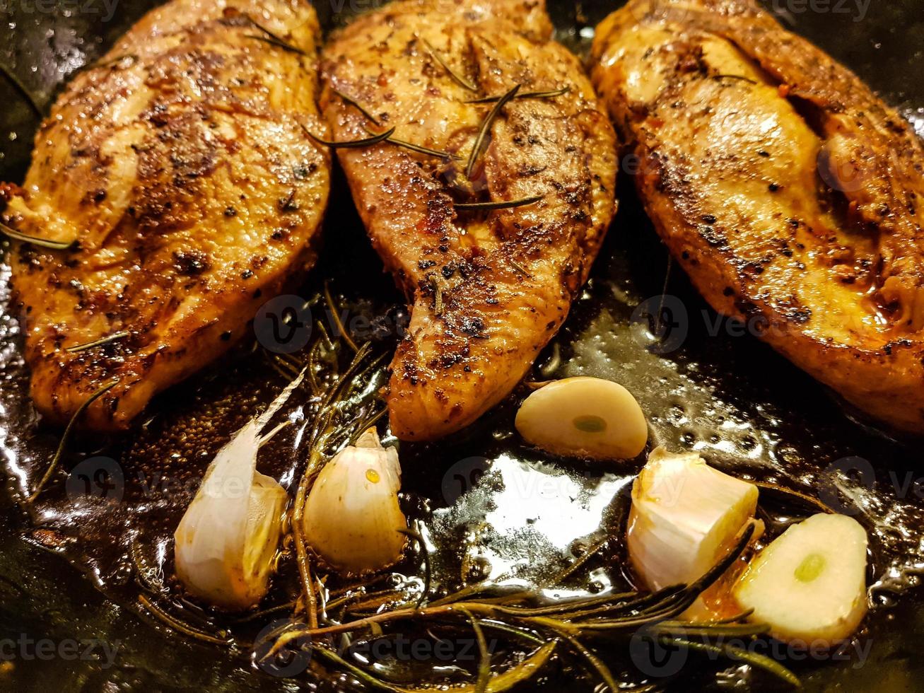 filled and marinated chicken breasts in a frying pan photo