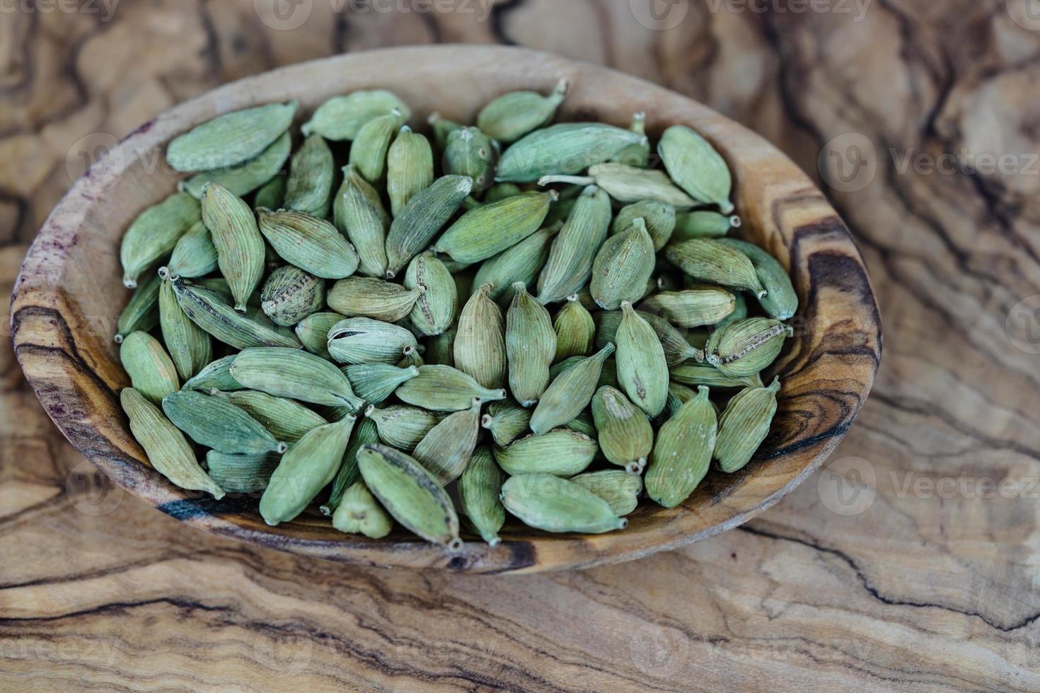 green cardamom on olive wood photo