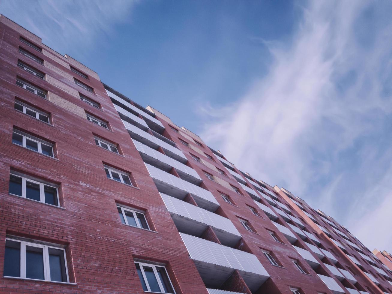 Edificio nuevo de ladrillo rojo de varios pisos desocupado. foto