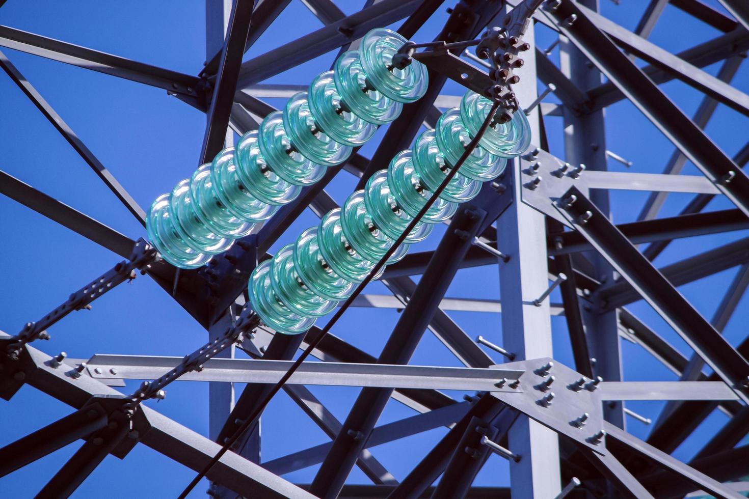 Glass linear isolator on high-voltage power tower. photo