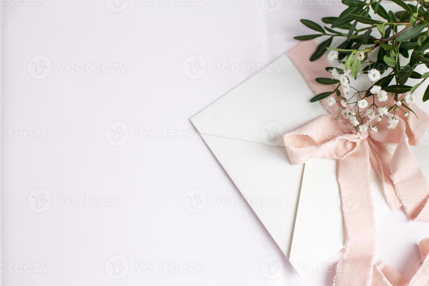 Envelope on a white-pink background with peach silk ribbon and pink photo