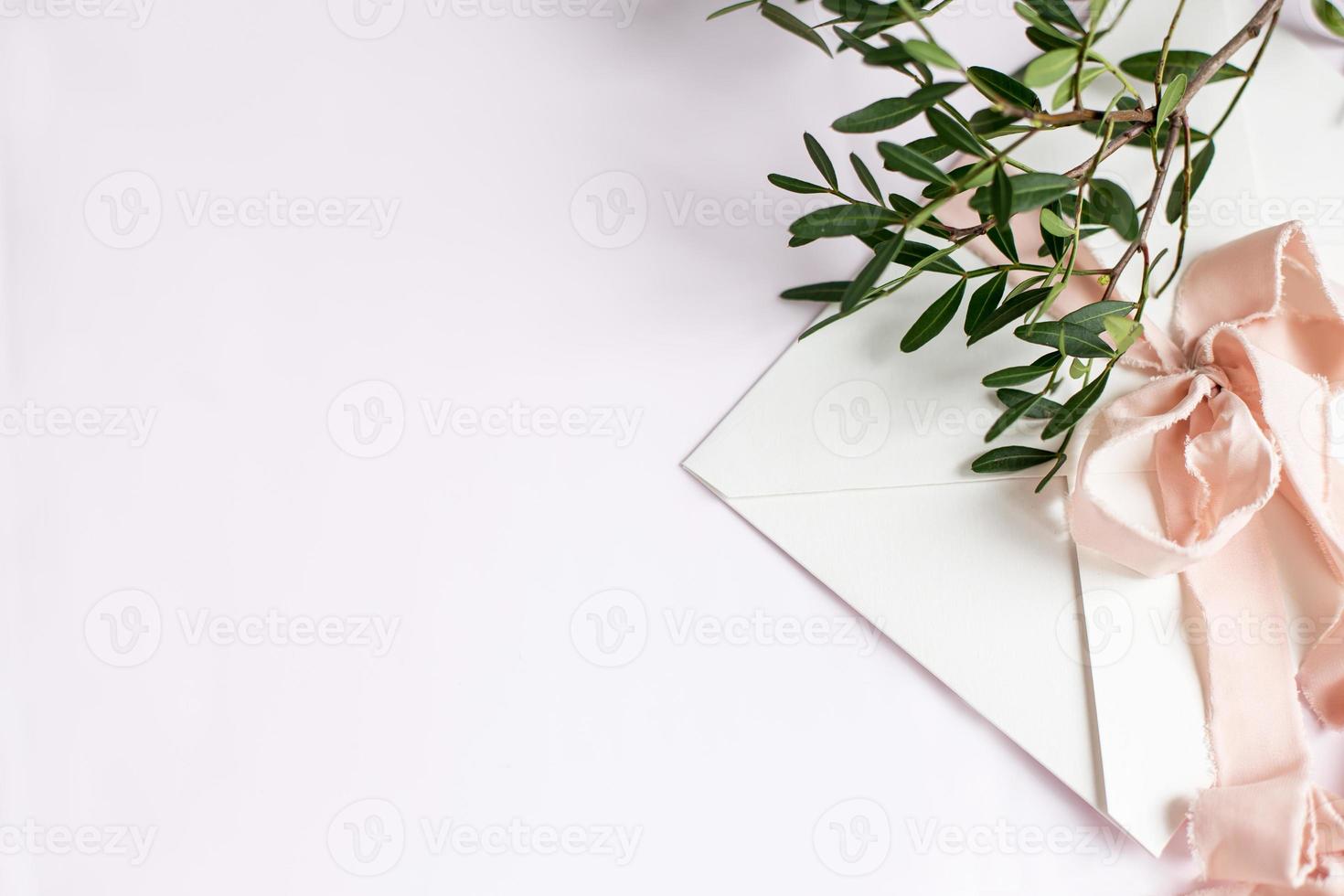 Envelope on a white-pink background with peach silk ribbon and pink photo