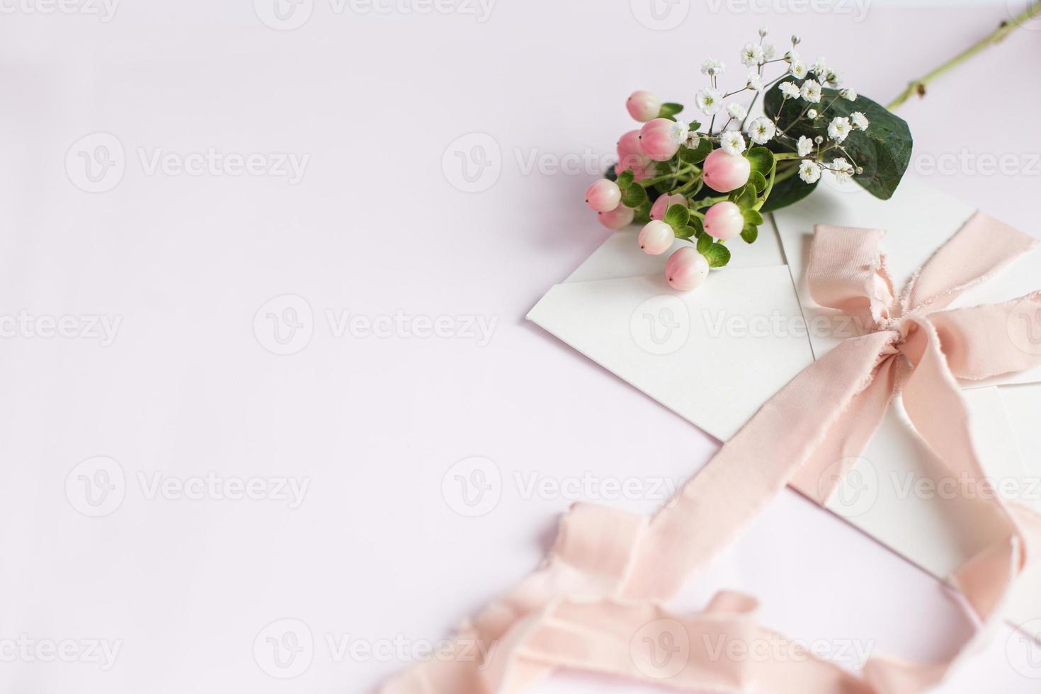 Envelope on a white-pink background with peach silk ribbon photo