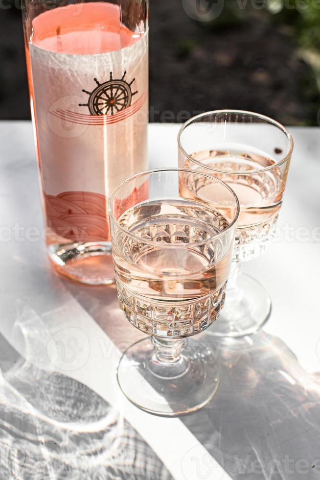 Rose wine in glasses and bottle. photo