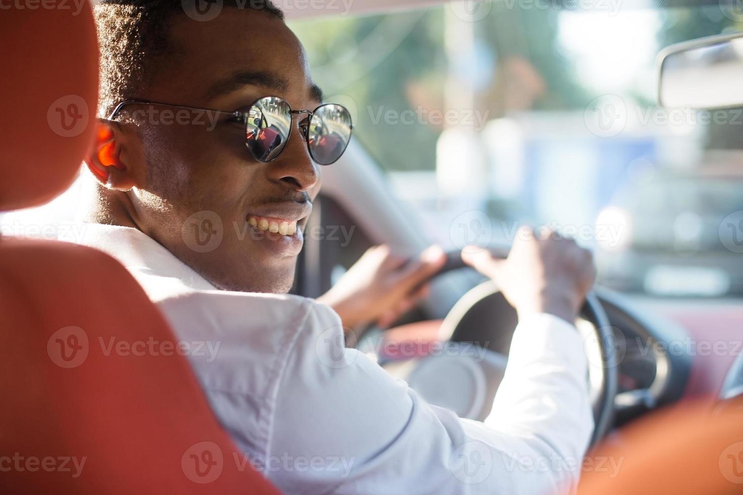 feliz afroamericano conduciendo un coche, en el verano foto