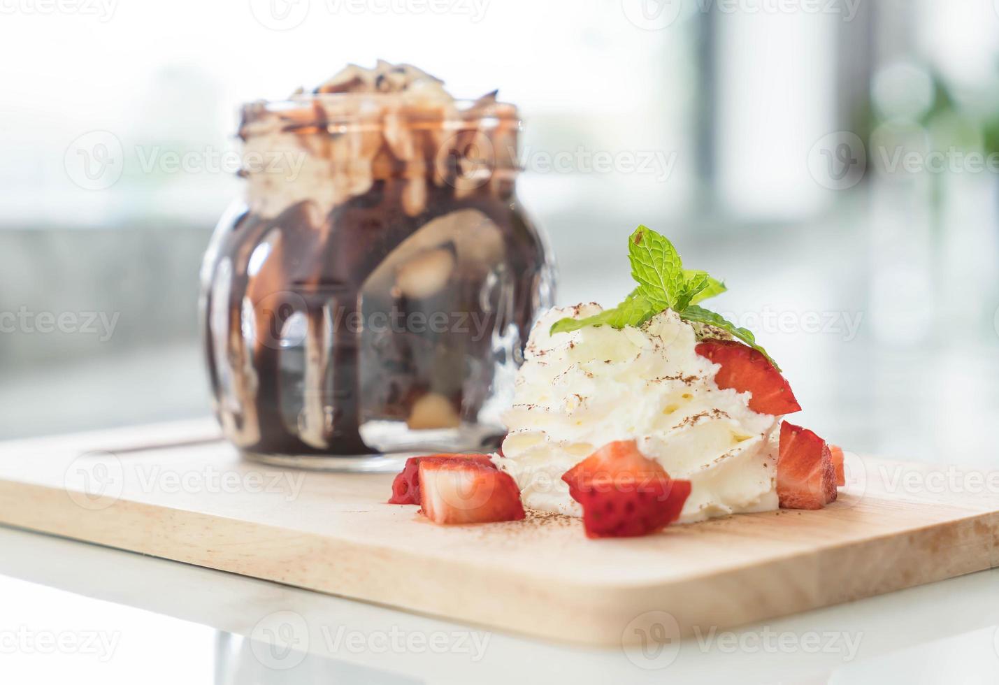 Chocolate brownies with vanilla ice cream, whip cream, and strawberry photo