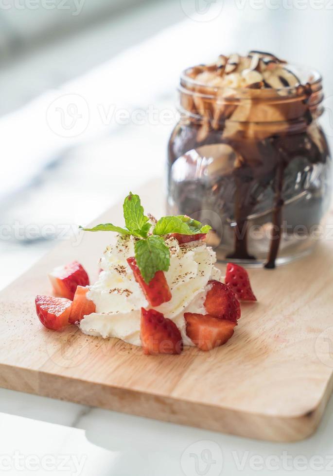 Chocolate brownies with vanilla ice cream, whip cream, and strawberry photo