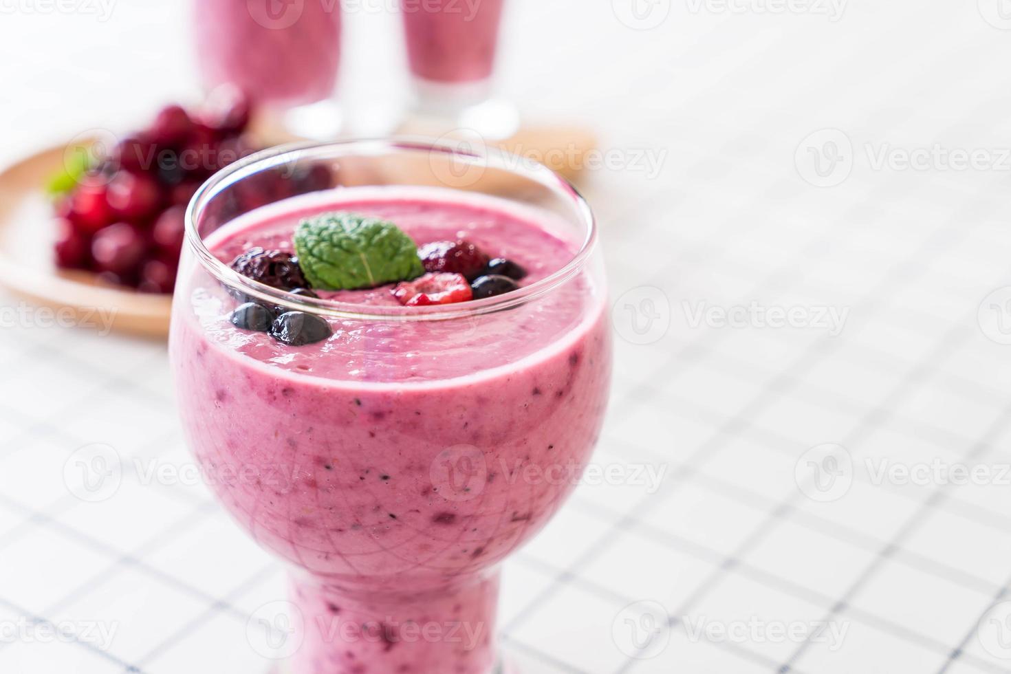 Bayas mixtas con batidos de yogur en la mesa foto