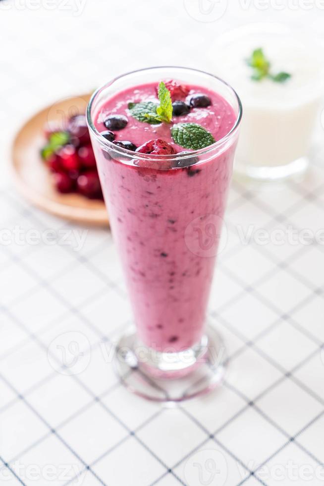 Bayas mixtas con batidos de yogur en la mesa foto