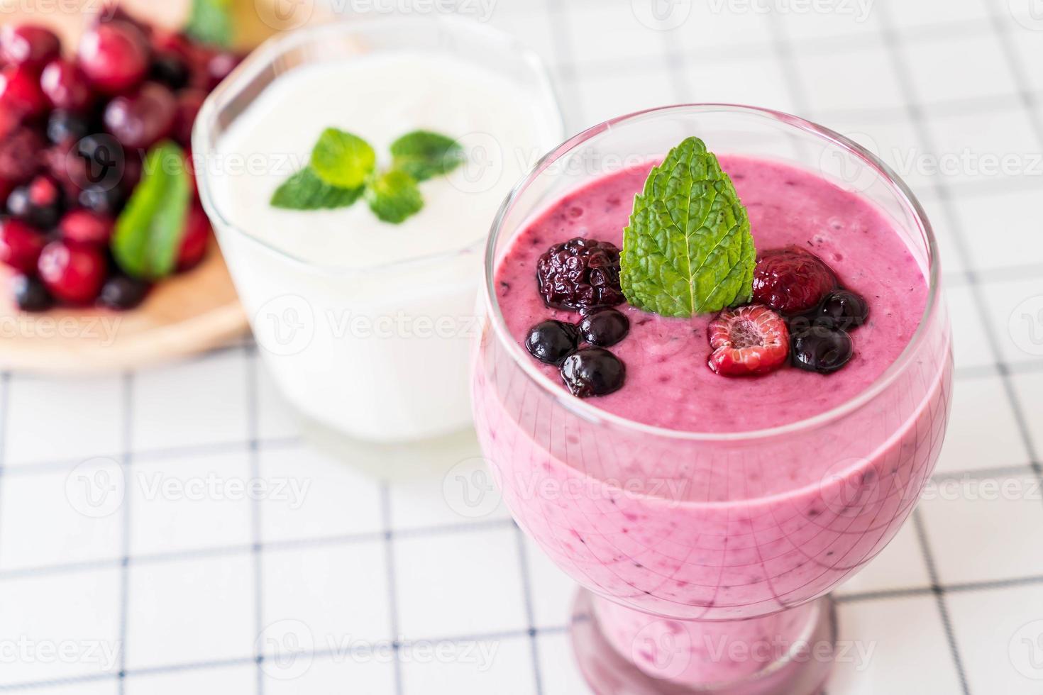 Bayas mixtas con batidos de yogur en la mesa foto