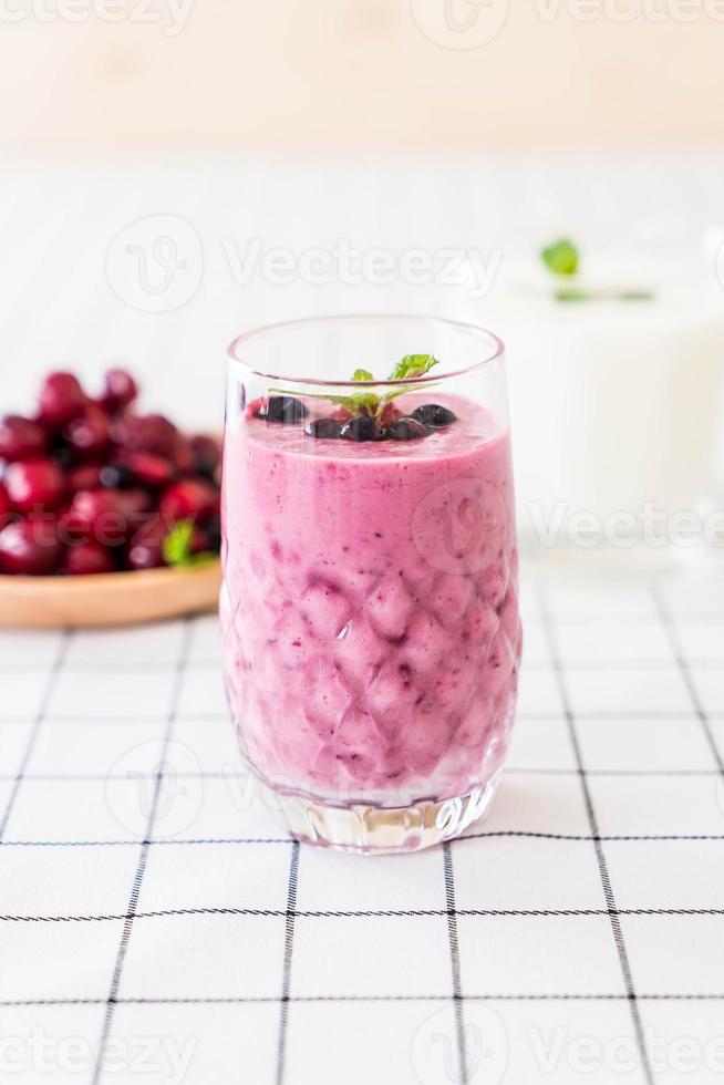 Bayas mixtas con batidos de yogur en la mesa foto