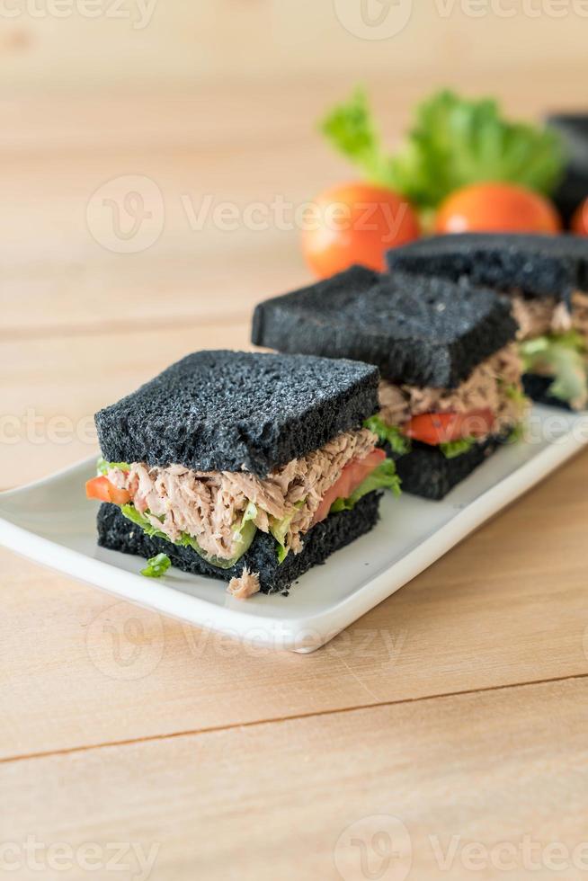 Sándwich de carbón de atún sobre tablero de madera foto