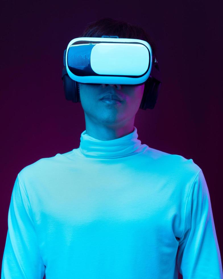 Young Asian man wearing virtual reality goggle watching 360 degree vdo photo