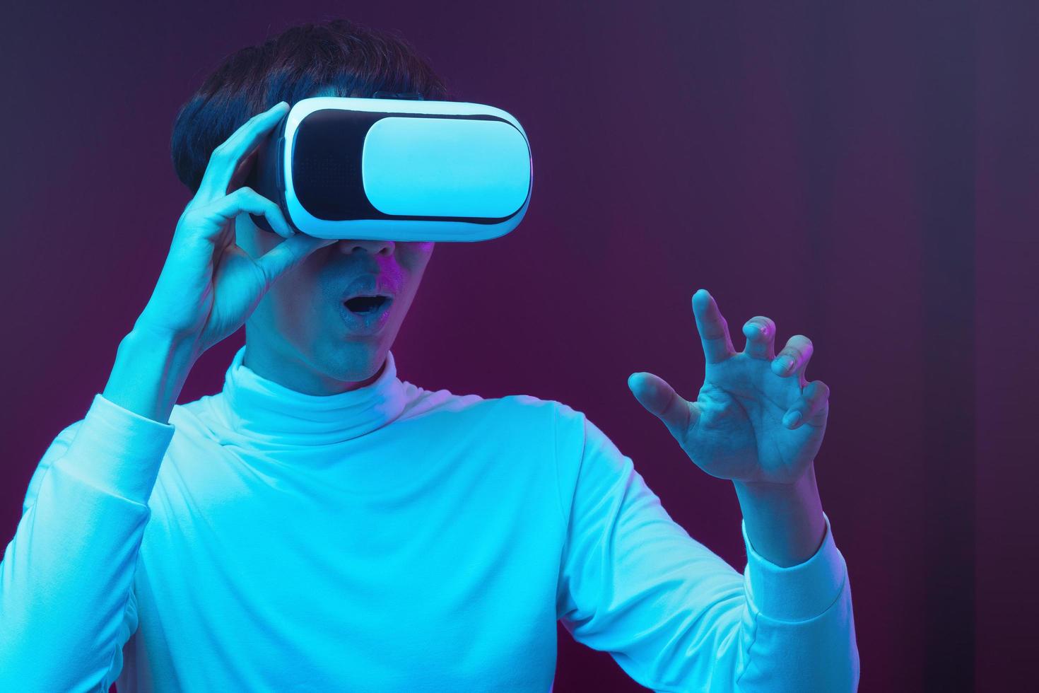 Young Asian man wearing virtual reality goggle watching 360 degree vdo photo