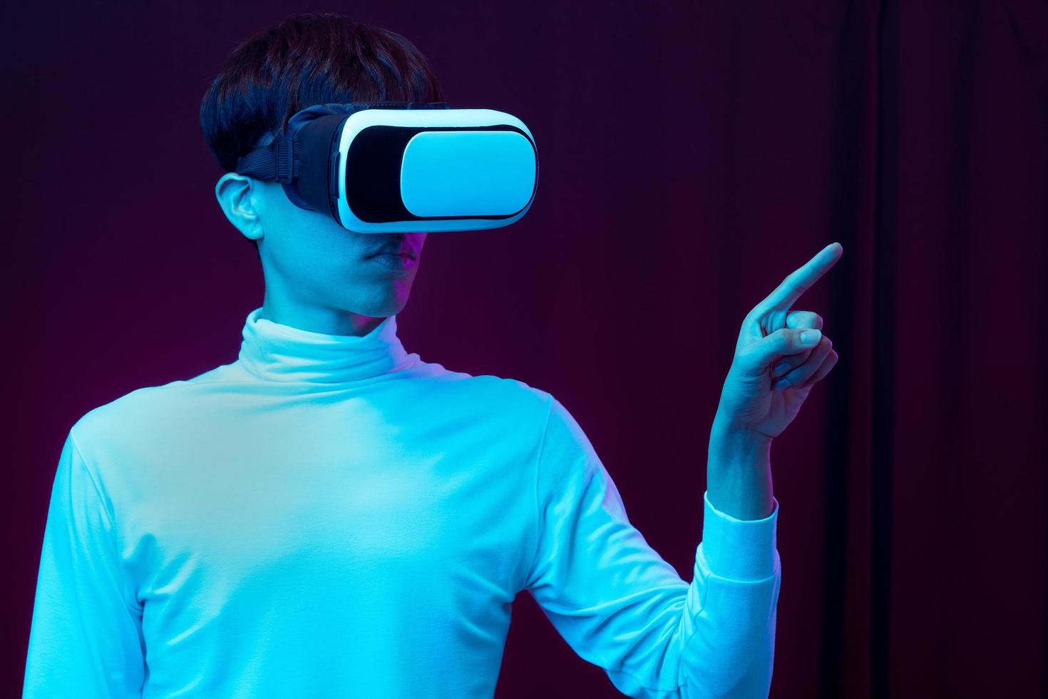 Young Asian man wearing virtual reality goggle watching 360 degree vdo photo