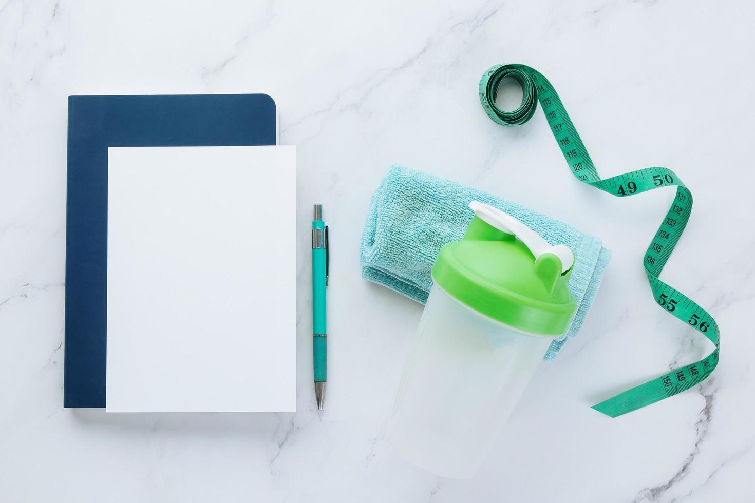 Blank white paper note and fitness equipment on marble background photo