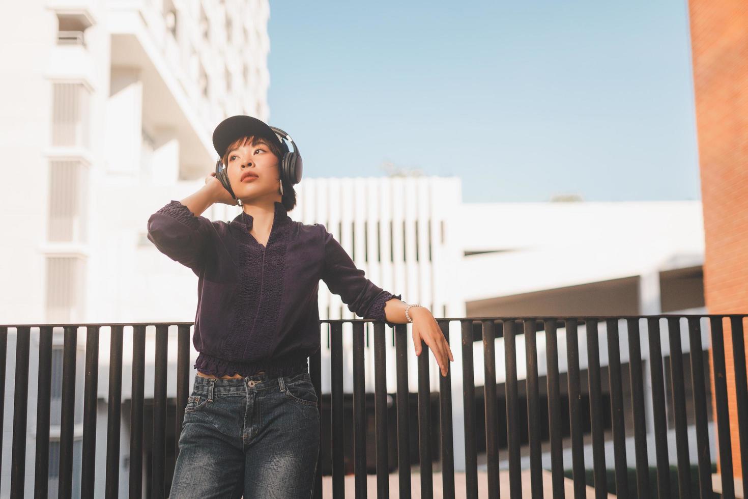 Feliz joven mujer asiática escuchando música con auriculares foto