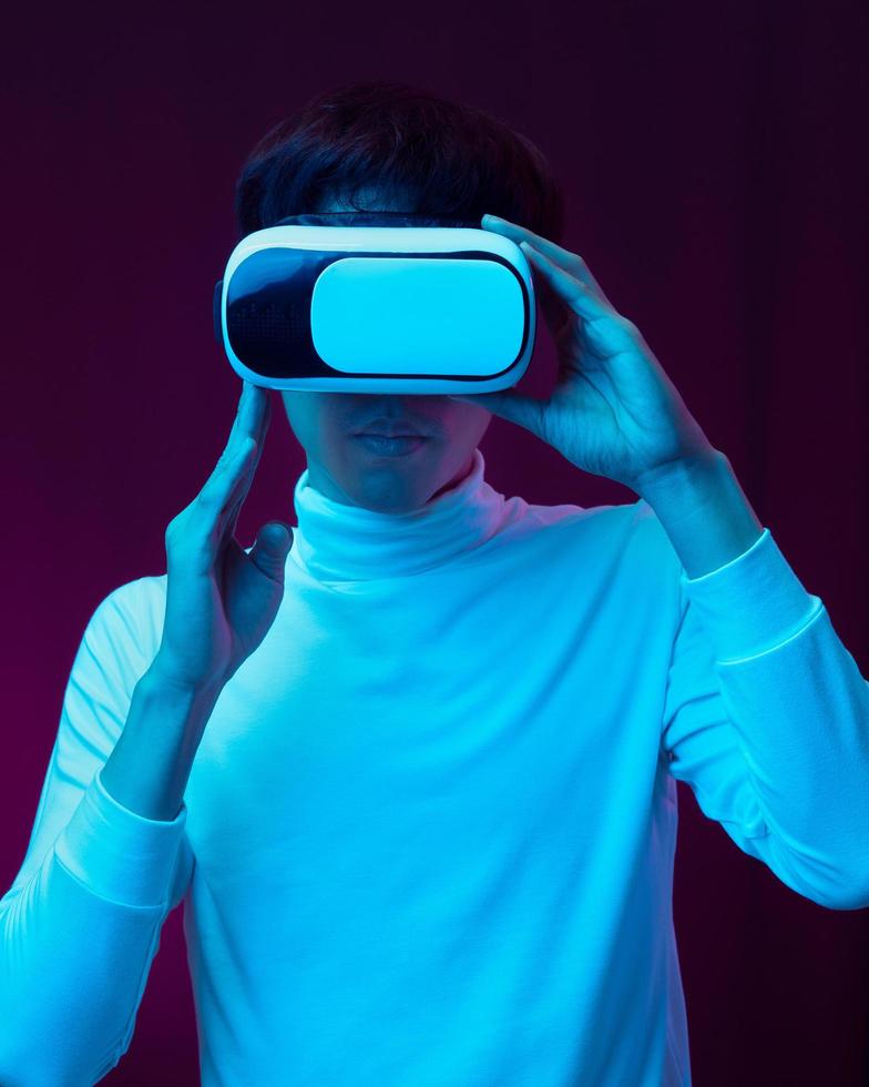 Young asian man wearing virtual reality goggles watching 360 video photo