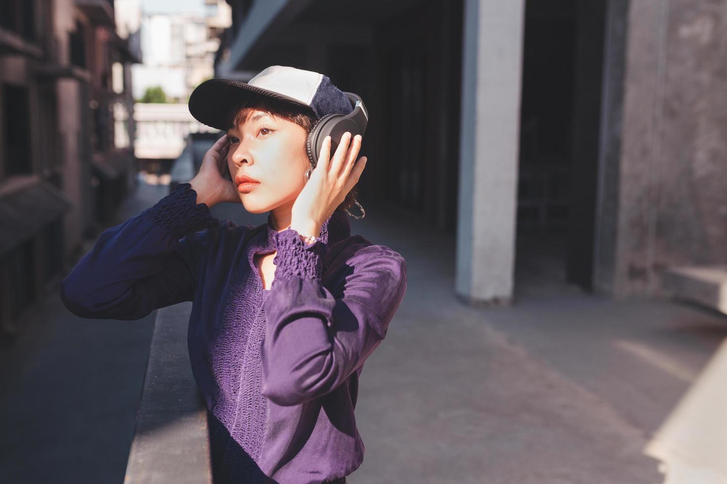 Feliz joven mujer asiática escuchando música con auriculares foto