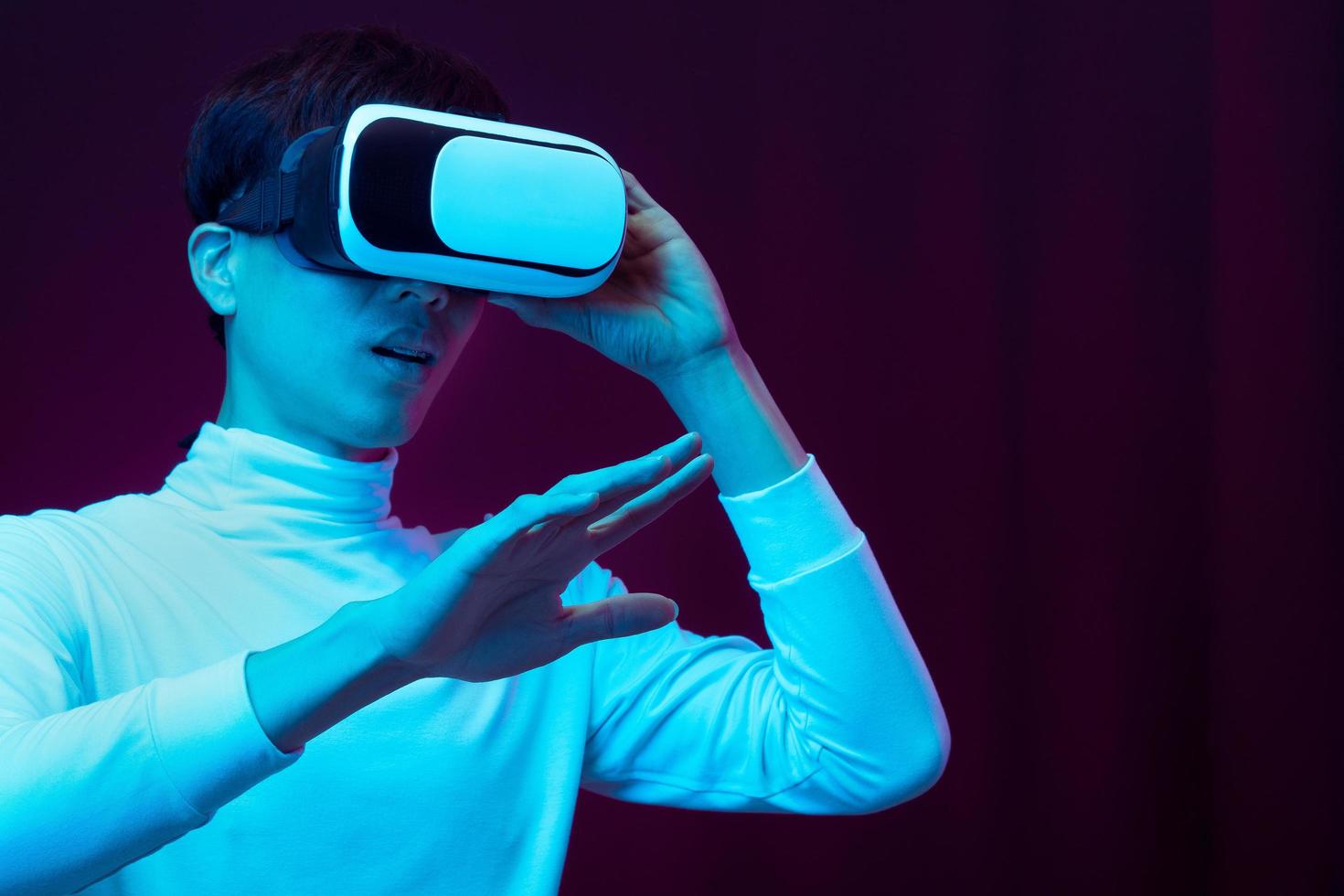 Young asian man wearing virtual reality goggles watching 360 video photo