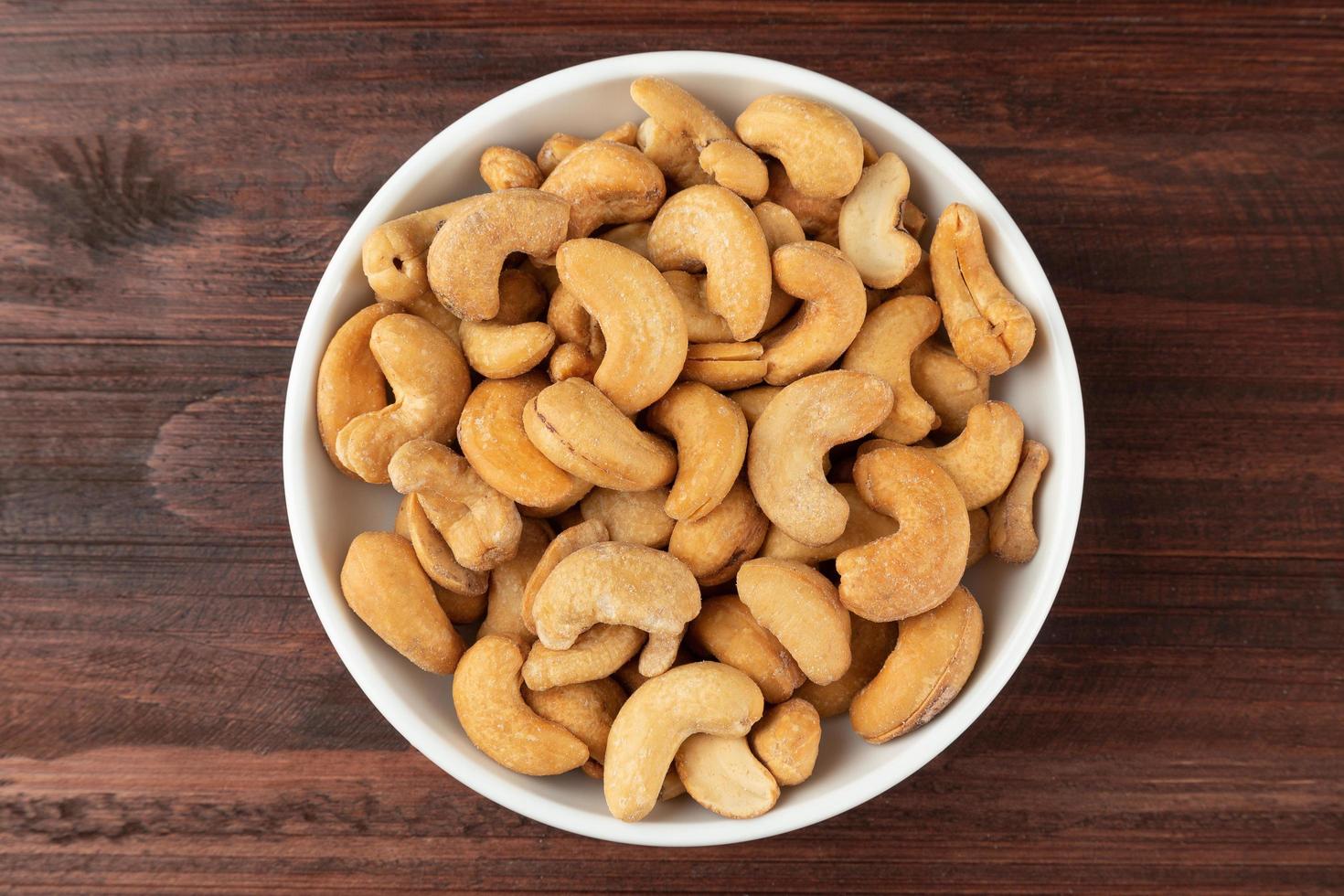 Top view of cashew nuts in white bowl on the table, Flat lay photo