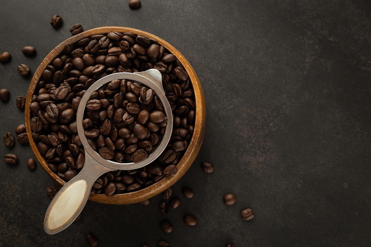 Coffee beans in wooden bowl on grunge background photo