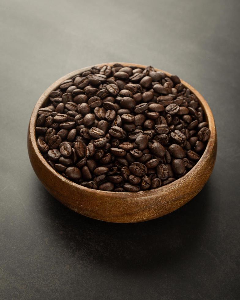 Coffee beans in wooden bowl on grunge background photo