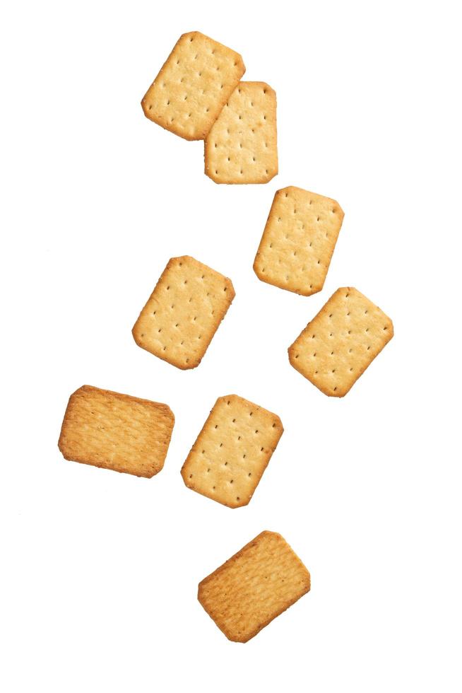 Cracker cookies falling isolated on white background photo