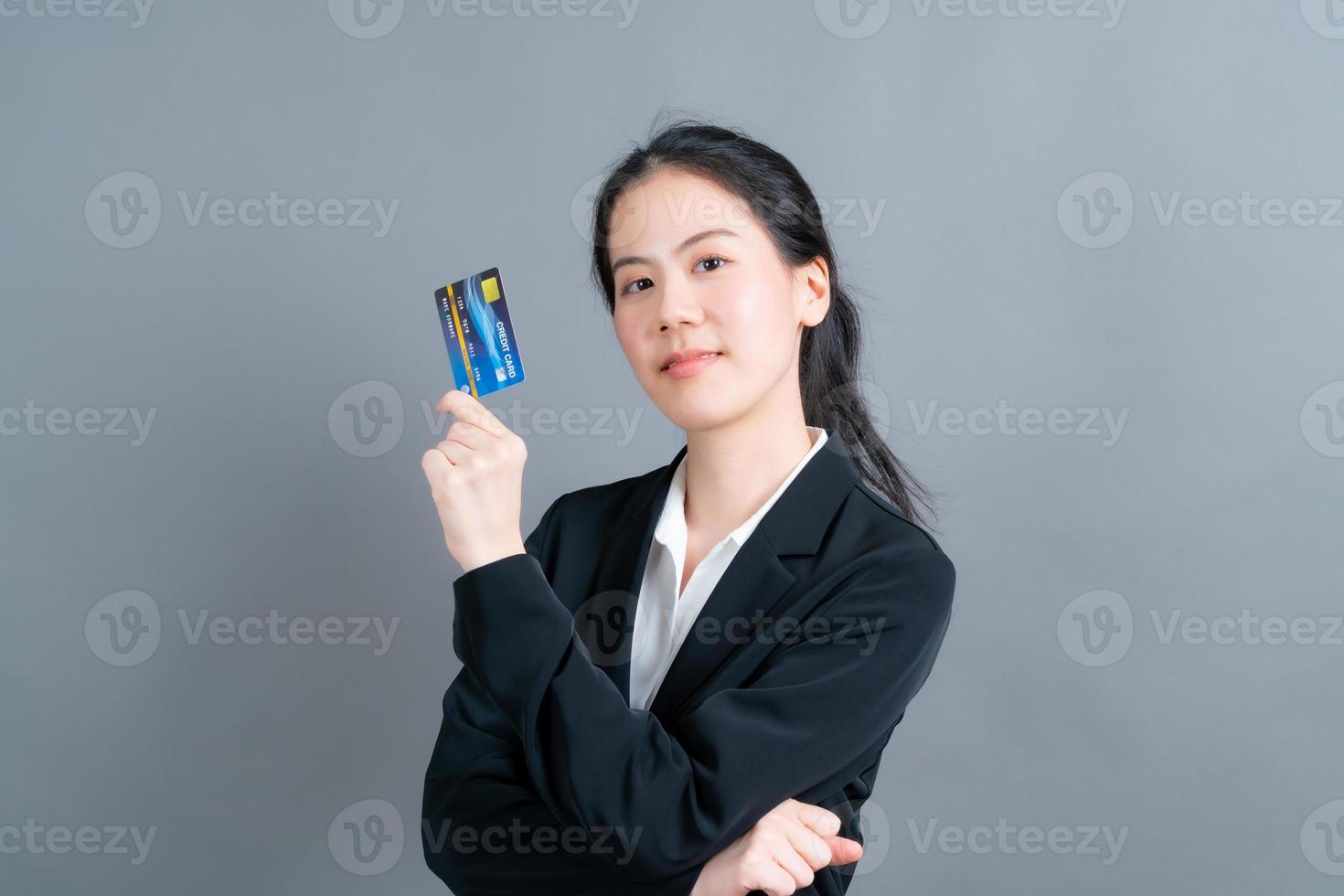 Portrait of a lovely young Asian woman showing credit card photo