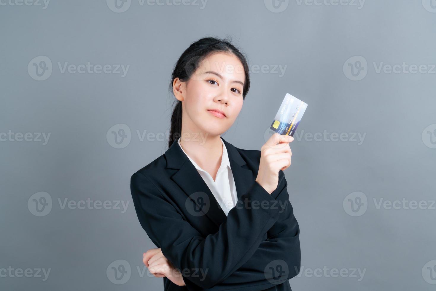 Portrait of a lovely young Asian woman showing credit card photo