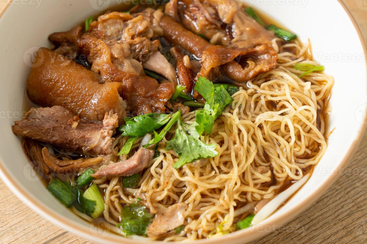 Stewed pork leg noodles in brown soup photo