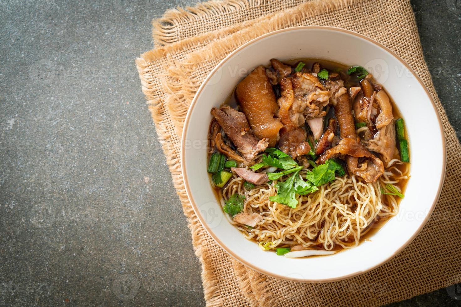 Stewed pork leg noodles in brown soup photo