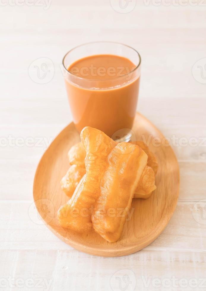 Deep-fried dough stick with milk tea on wood photo