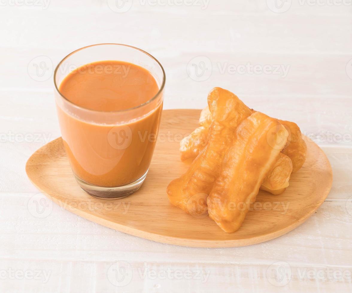 Deep-fried dough stick with milk tea on wood photo