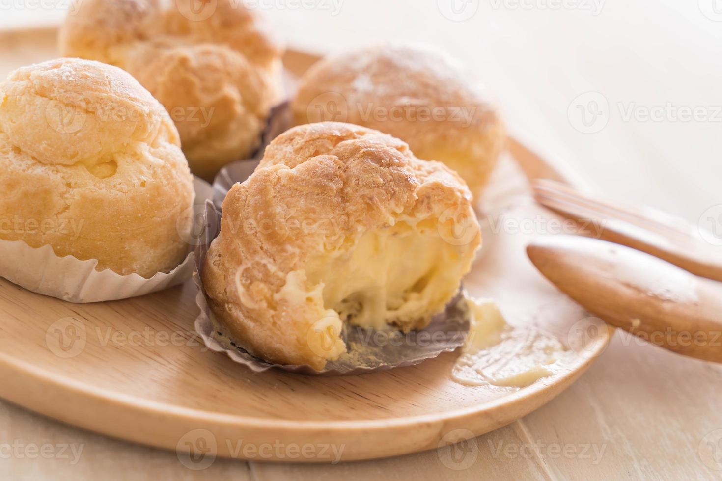 Cream puff on wood plate photo