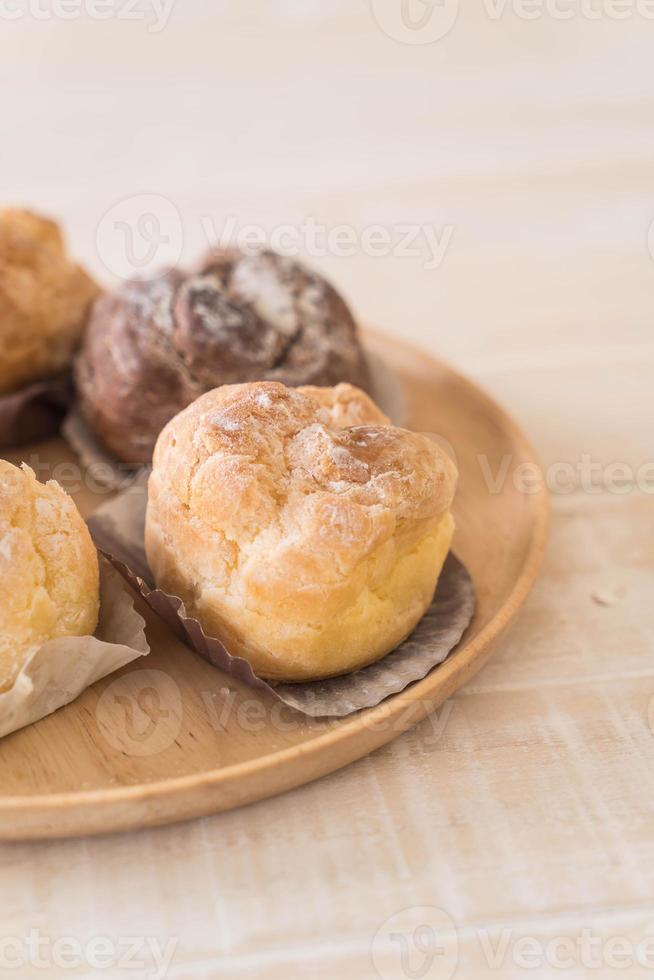 Cream puff on wood plate photo