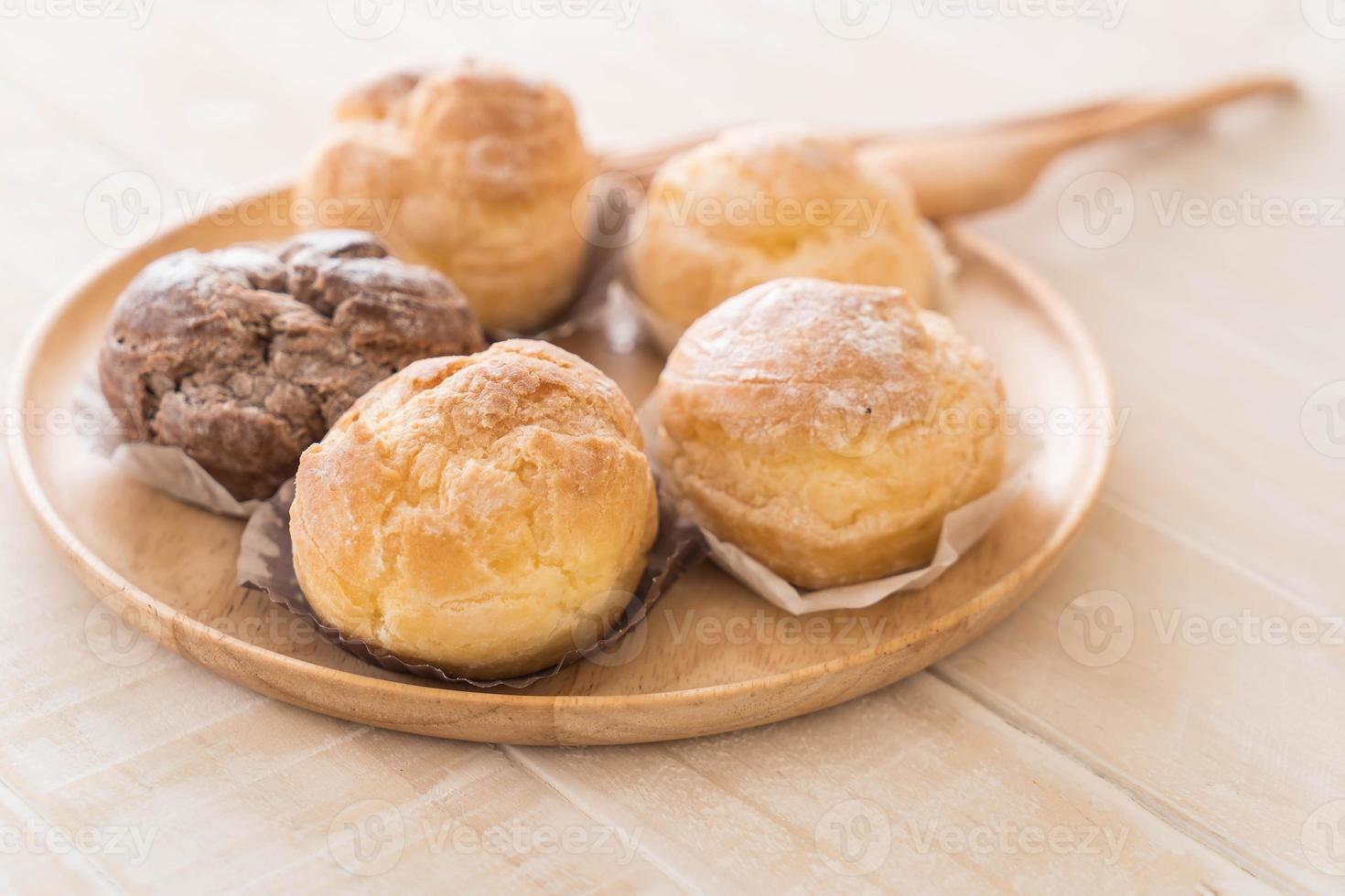 Cream puff on wood plate photo