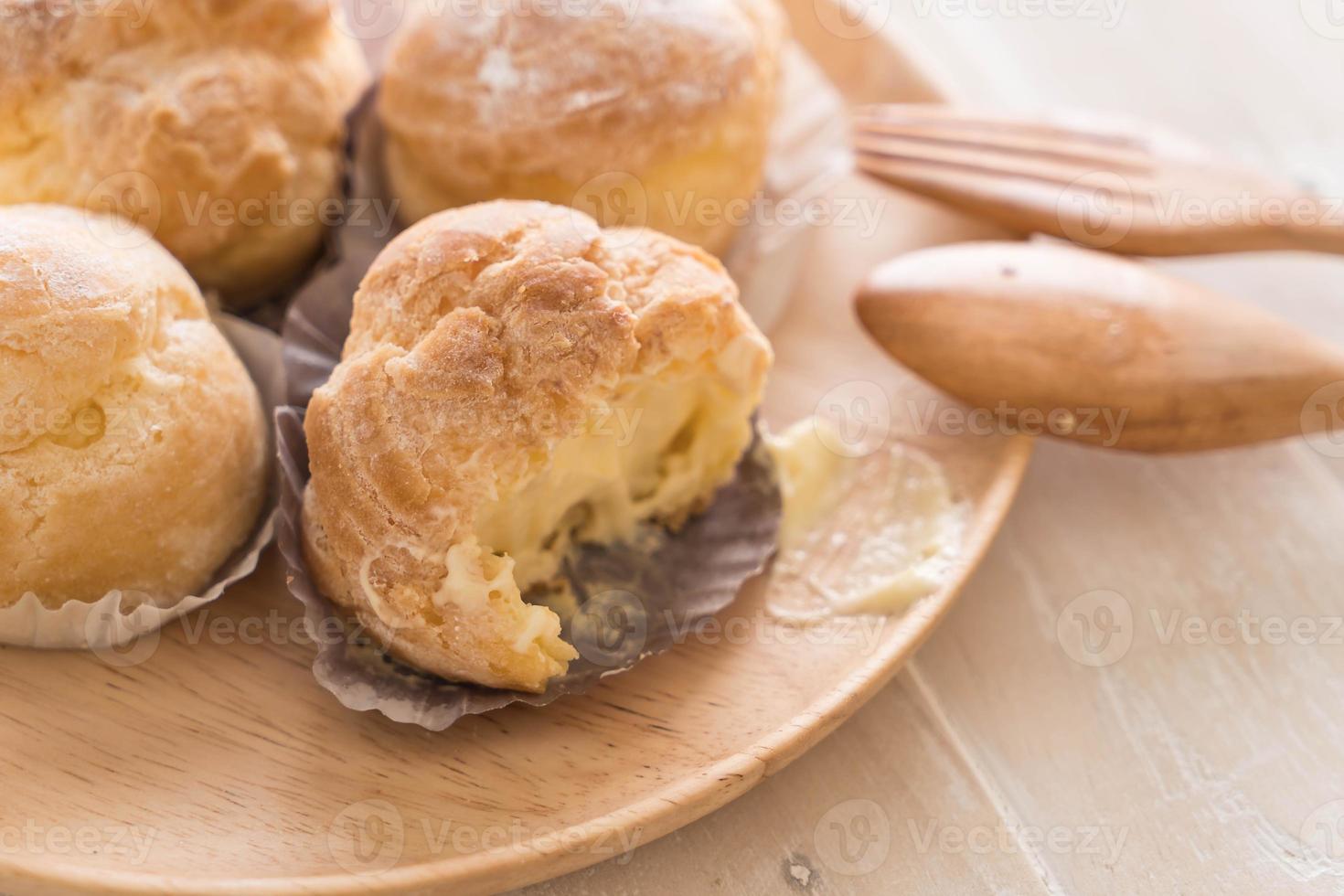 Cream puff on wood plate photo