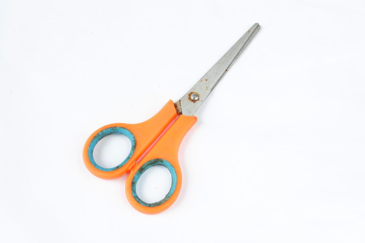 Closeup shot of scissors with orange handles isolated on a white photo