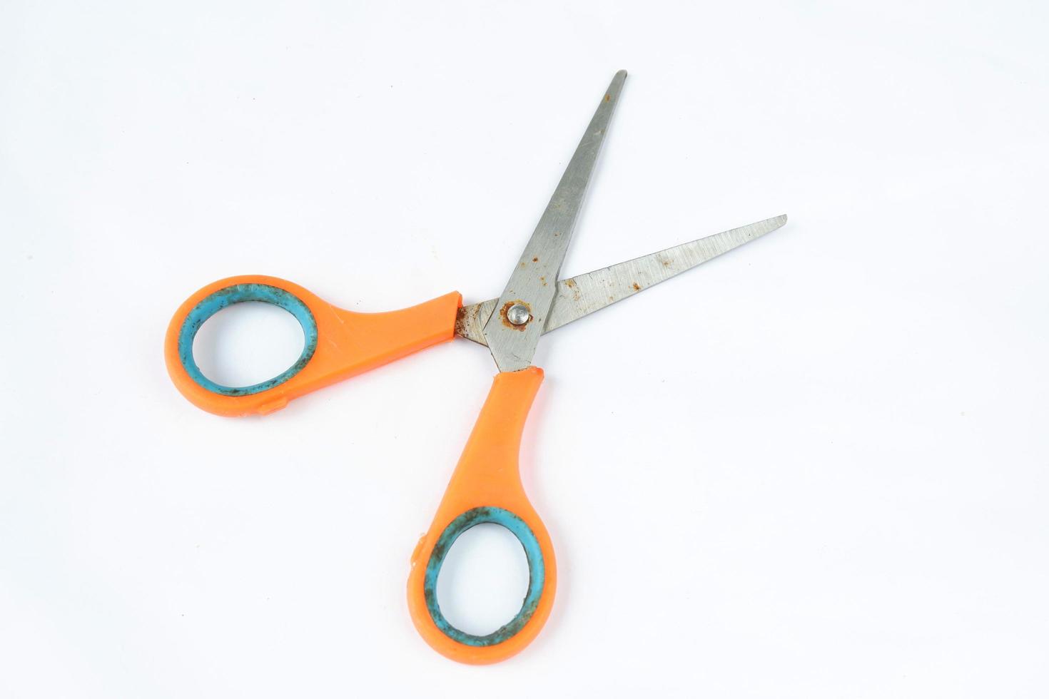 Closeup shot of scissors with orange handles isolated on a white photo