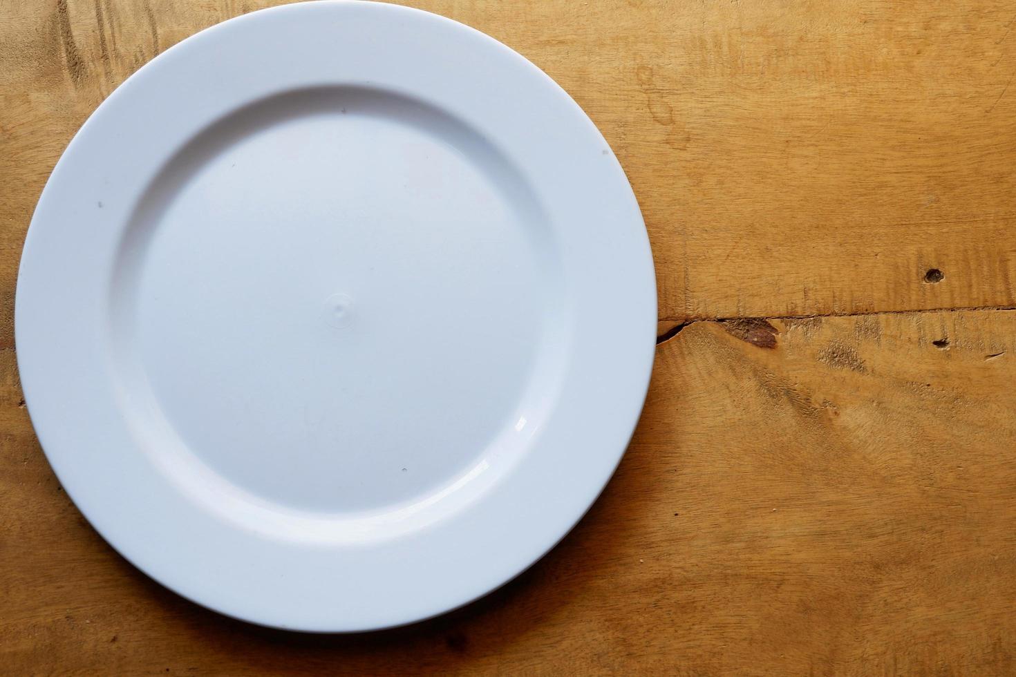 White plate on wooden table with copy space photo