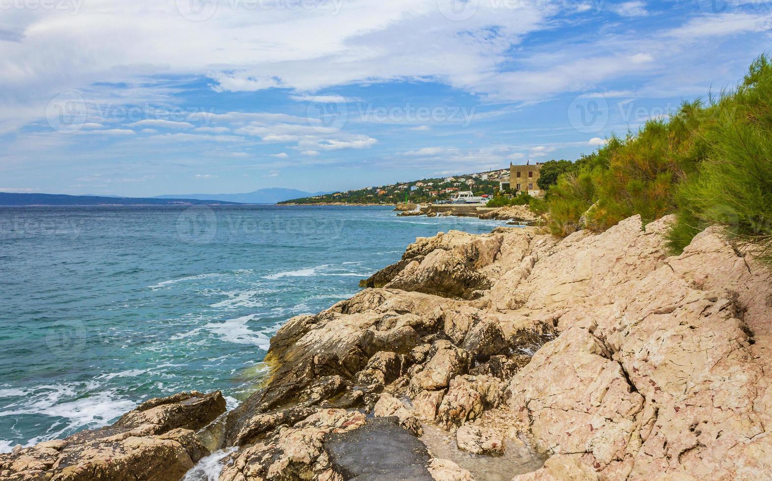 playa turquesa y rocosa y paseo marítimo novi vinodolski croacia. foto