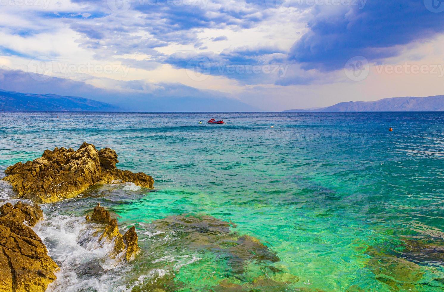 playa turquesa y rocosa y paseo marítimo novi vinodolski croacia. foto