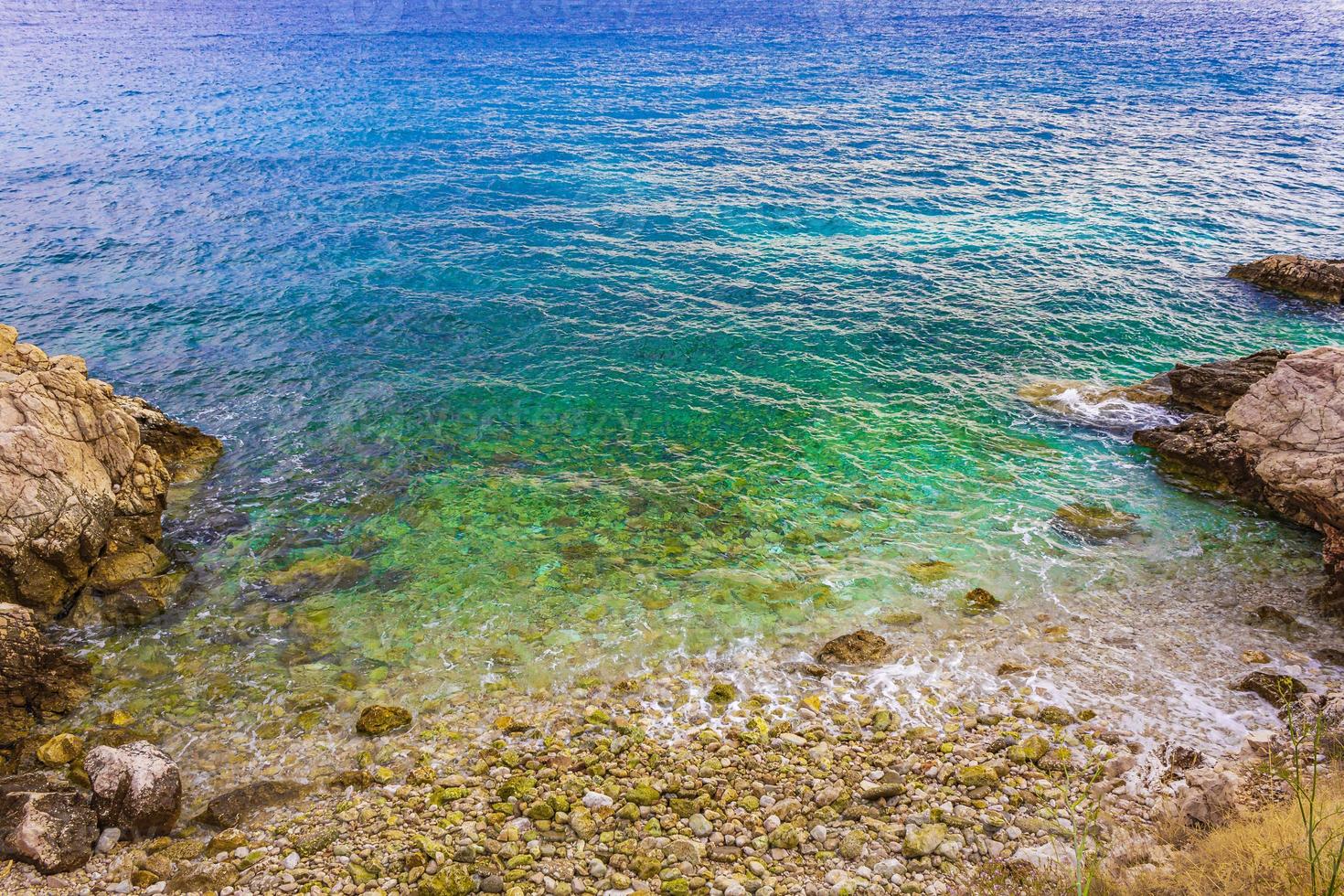 playa turquesa y rocosa y paseo marítimo novi vinodolski croacia. foto