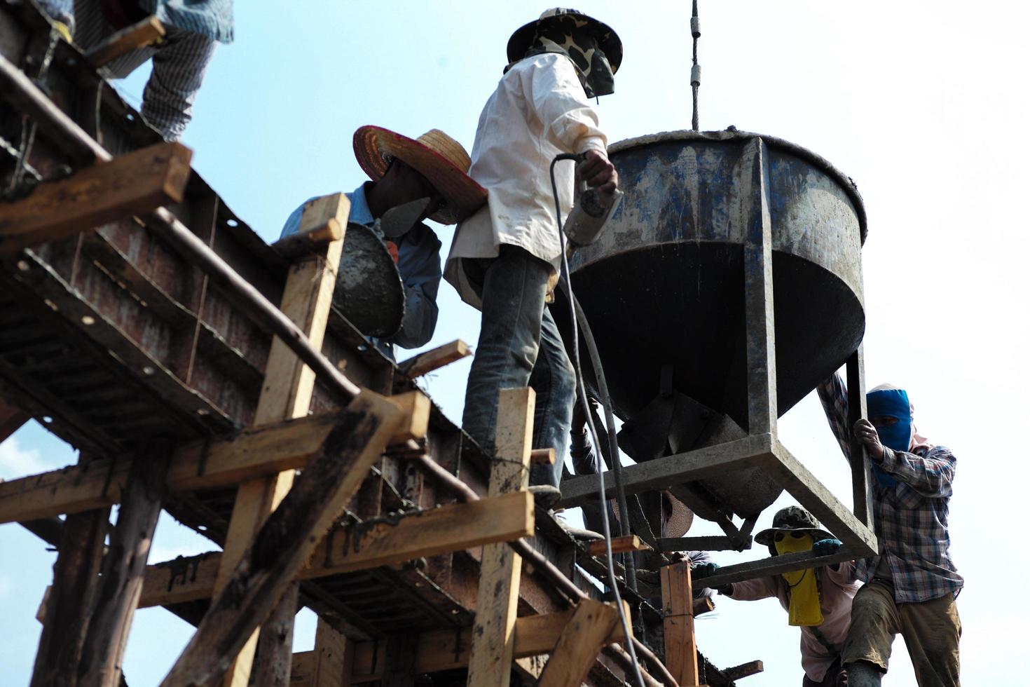 High angel view group of workers pouring the mixed cement from bucket photo