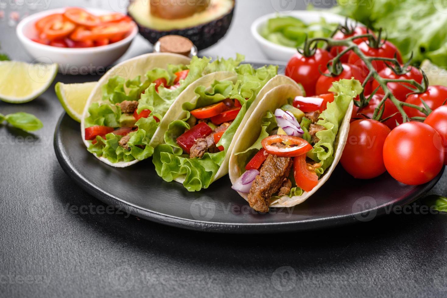 tacos mexicanos con carne, tomate, aguacate, cebolla y salsa salsa foto