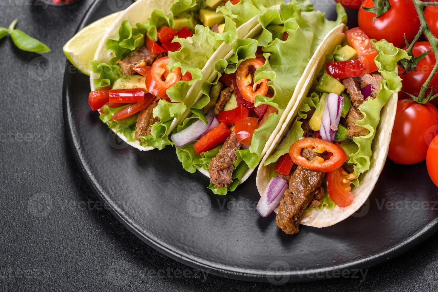 tacos mexicanos con carne, tomate, aguacate, cebolla y salsa salsa foto