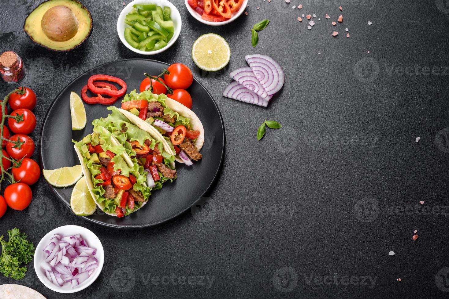 tacos mexicanos con carne, tomate, aguacate, cebolla y salsa salsa foto