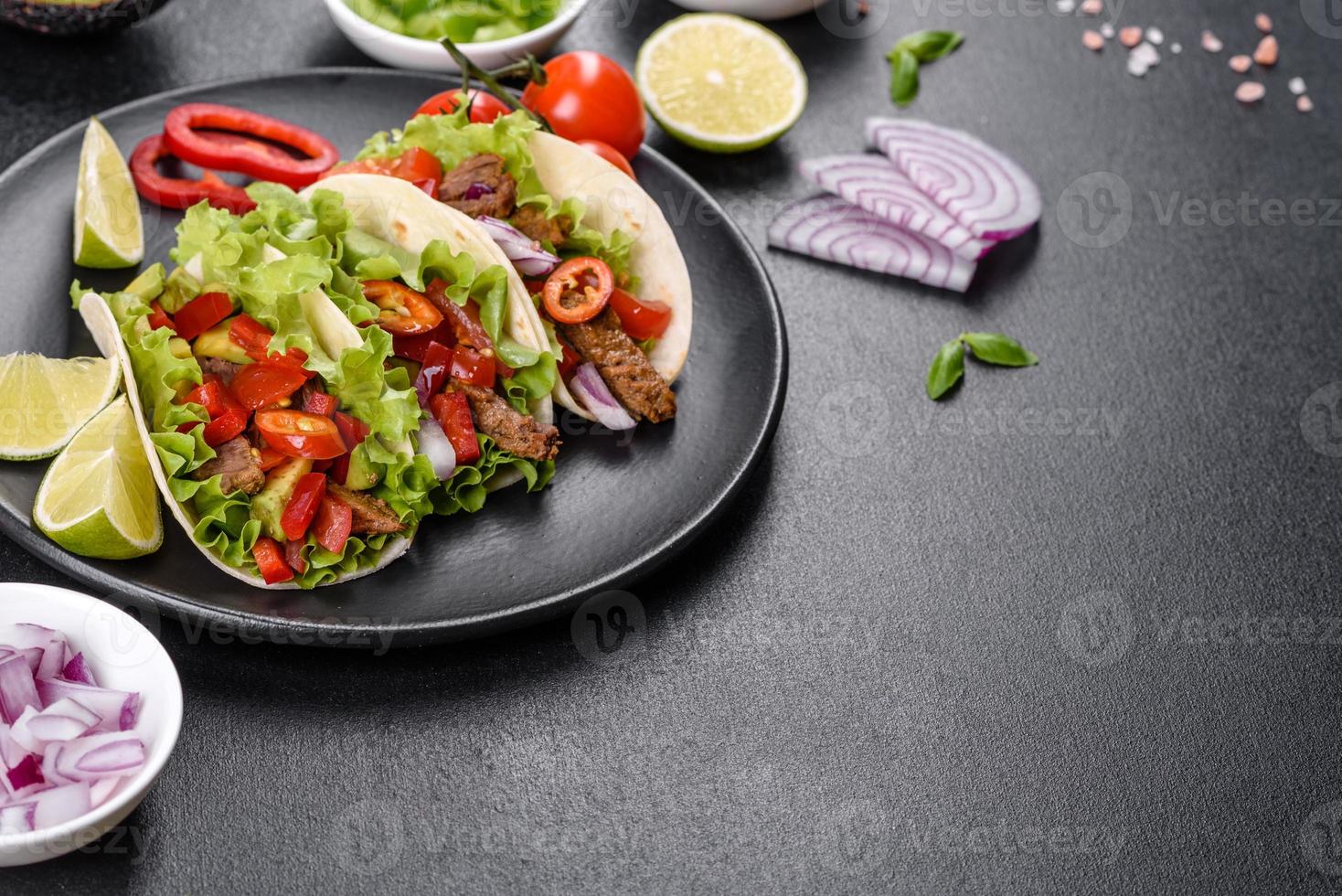 tacos mexicanos con carne, tomate, aguacate, cebolla y salsa salsa foto