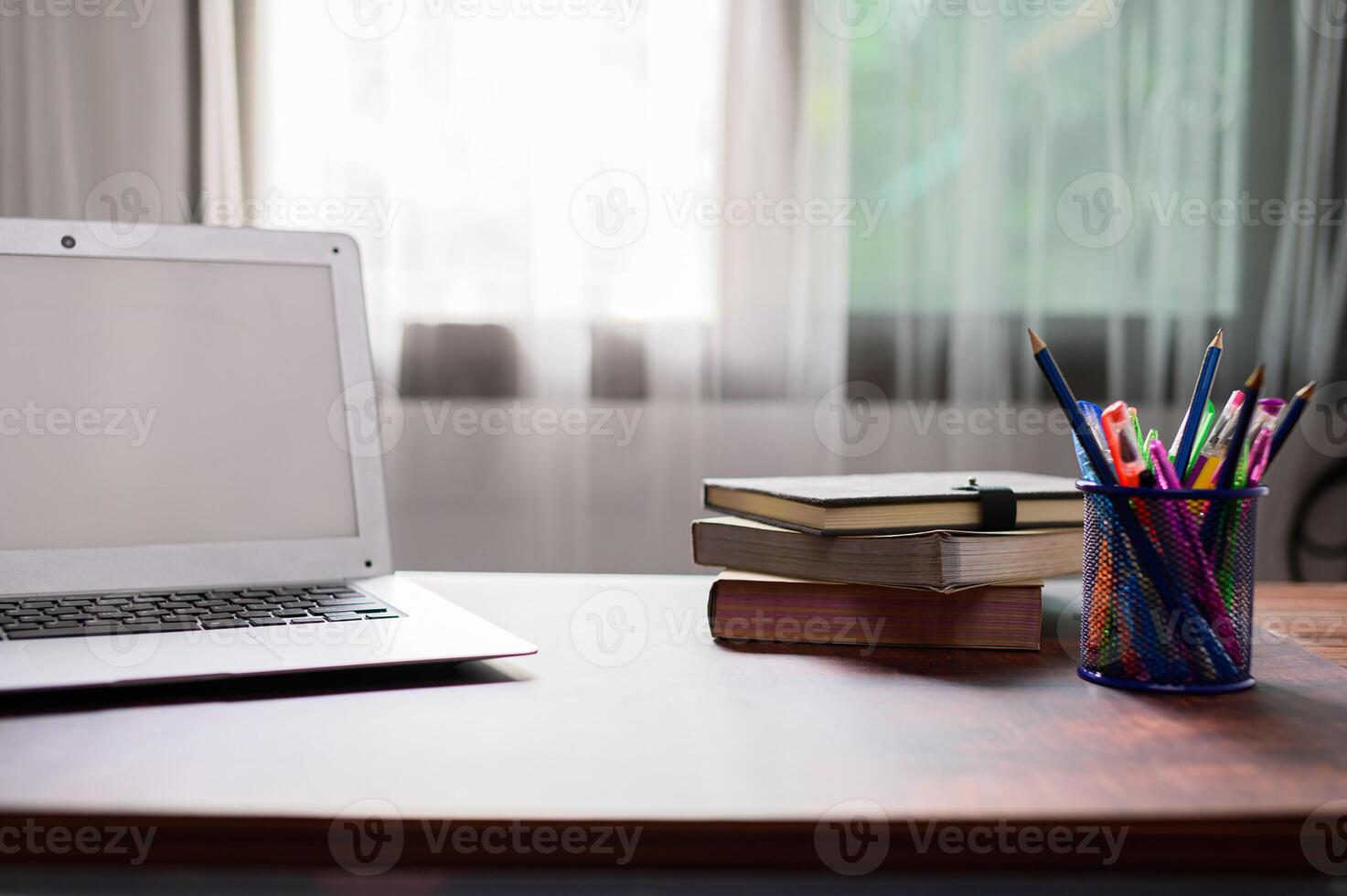 A laptop sitting on a desk with a cup of coffee photo